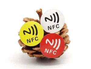 Tre etichette NFC in giallo, bianco, e rosso sono apposti su una pigna.