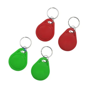 Upat ka *rfid key fob programming (1)* devices, ang matag usa adunay gilakip nga key ring, gihan-ay sa puti nga background. Ang duha sa mga fobs pula ug duha ang berde.