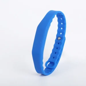 A RFID Wrist band featuring a blue adjustable rubber strap and a metallic button clasp, showcased on a white background.